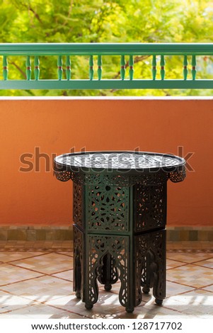 Moroccan pierced metal small side table with a hexagon base and round top.  Location: Marrakech, Morocco