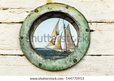 Porthole Window Looking Out At An Old Sailing Ship. Image Has A Vintage Look And Color Palette.