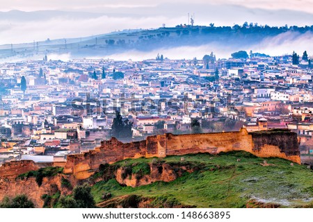 Fez, Morocco Aerial View On A Frosty Foggy Winter Morning. The Ancient City Wall Is In The Foreground And Behind It, An Overview Of The Old Neighborhood.