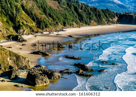 Aerial view of the scenic Pacific Northwest coast, with ocean, sea stacks, sandy beach and forested mountains. Location: Crescent Beach, Oregon, USA