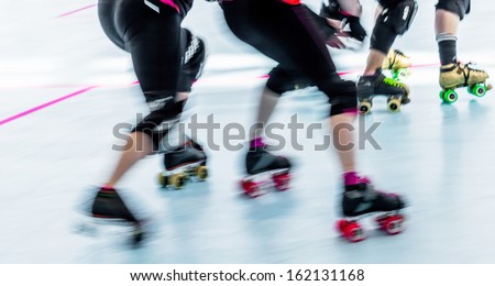 Panning action shot of skaters in a roller derby. Pan with motion blur.