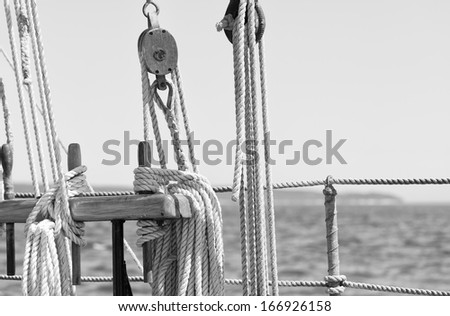 Nautical ropes and pulleys on a sailboat at sea with close up details in black and white. Copy space