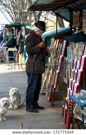 Paris - Dec 26, 2013: A Man Shops At The Famous Book Stalls Along The Seine River. The Tradition Of The Second-Hand Booksellers, Called Bouquinistes, Dates Back To The 16th Century.
