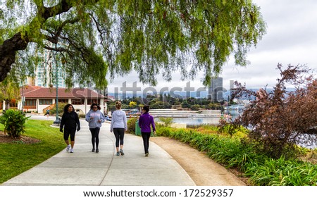 OAKLAND,CA-JAN.11,2014:People on the newly paved 3.4 mile pedestrian path around Lake Merritt in downtown Oakland.The lake was recently renovated, adding new parks and an amphitheater.