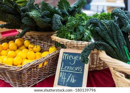Fresh lemons and kale on display in baskets at a farmers market. Concept for farm to table.