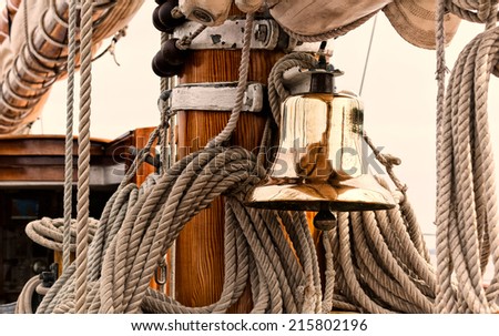 Shiny brass ship\'s bell on a vintage sailboat.