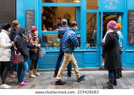 PARIS-DEC 31, 2013: People line up to buy crepes at a shop on rue des Rossiers in the Marais district, the oldest neighborhood in Paris. The sweet or savory thin pancakes are a popular snack in Paris.