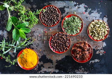 Fresh herbs and whole spices displayed on a vintage metal cooking sheet. Overhead top view shot looking down.