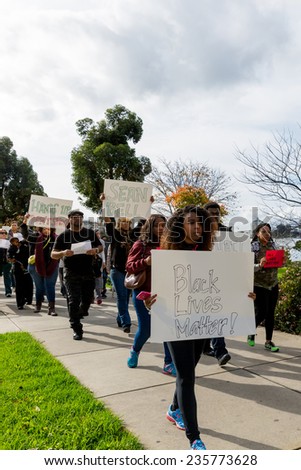 OAKLAND, CA-DEC 6,2014: Marchers protest recent Grand Jury decisions not to charge white police officers in the deaths of unarmed black men in Missouri and New York. Signs:Black Lives Matter