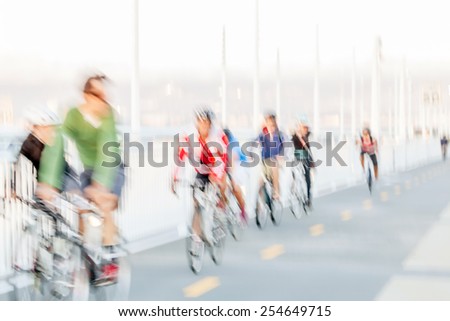 People riding bikes with intentional motion blur. High key image with copy space. Abstract  impressionist style.