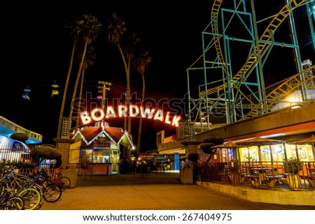 SANTA CRUZ, CA-AUG 2, 2014: Night view of the Santa Cruz Beach Boardwalk, seen  from the front entry with its bright neon sign. The vintage seaside amusement park first opened in 1907.