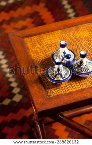 Leather top side table with Moroccan decorative ceramic accessories. Interior close up