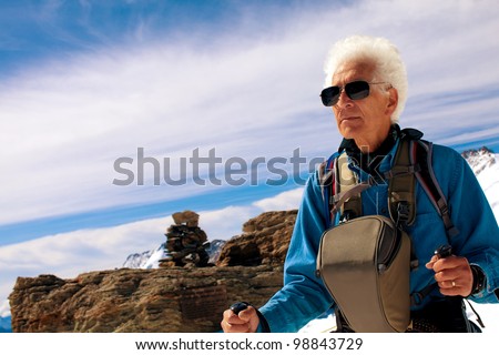 Active senior man hiker. Adventure trekking in the Swiss Alps. Concept: Active retirement. Copy space