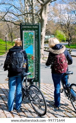 Bicyclists in Central Park, New York City, stop to check a map kiosk