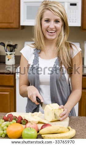 A beautiful woman cutting up fruit
