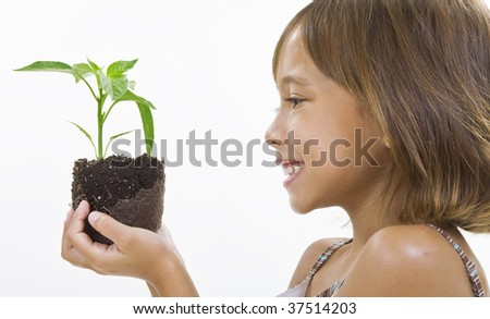 A girl studies a young plant.