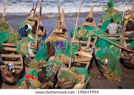 ACCRA, GHANA - MARCH 20: Unidentified group of African fishermen working on Cape Coast beach on March 20, 2014 in Accra, Ghana. Cape Coast is famous fishery village in Ghana.