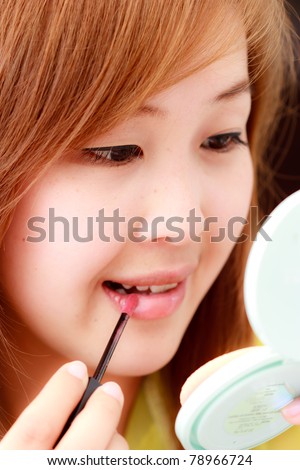 Asian woman making up her face
