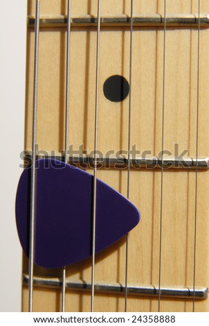 Close up of Guitar Pick on a Fret Board