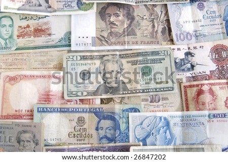 Old cash money from different countries around the world. With a twenty dollar US dollar bill on top.