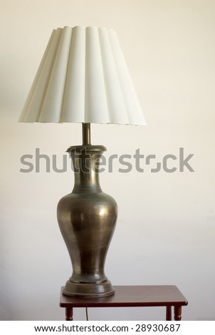 Still life of a large table lamp on a small table. Nobody, white background.