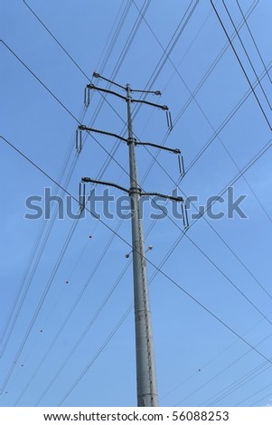 Crossed wires and steel support of overhead power transmission line on sky background