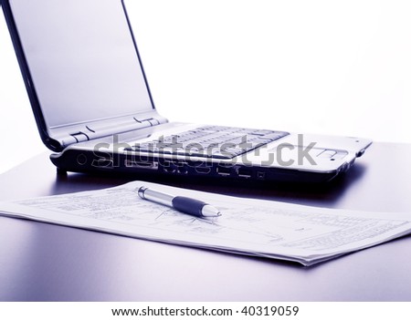 Working in the office: computer, papers and pen