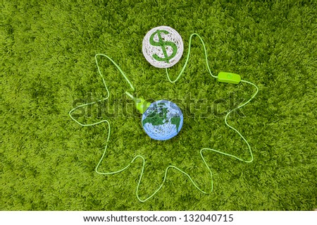Pumping money from the world. Made of thread balls connected by green wire, on the green carpet.