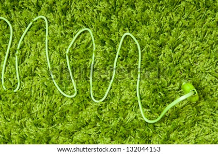 Plug in earth. Green electric plug on the green carpet.