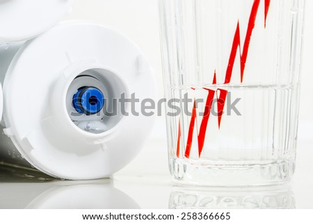 Water filters and glass of water with drinking straw.