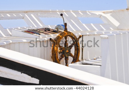 The wood steering wheel of a captain\'s bridge on the yacht