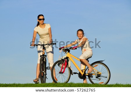 Mother and her daughter riding on a bicycles