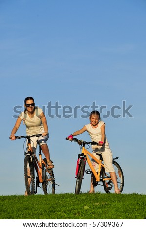 Mother and her daughter riding on a bicycles