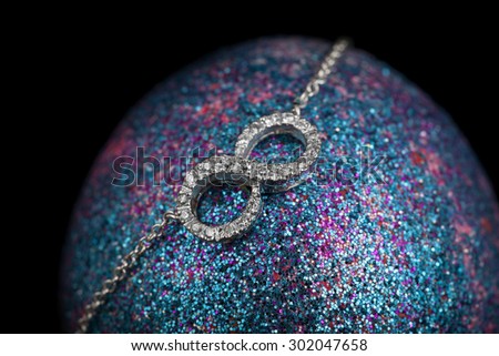 infinity necklace on Easter egg on black background