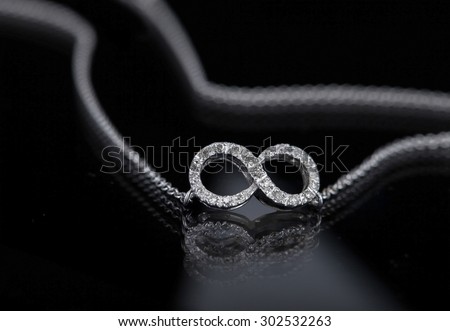 infinity necklace on black background