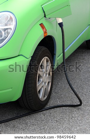 sporty cute green energy efficient electric car with charger