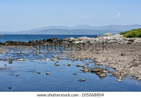 A beautiful scenic Atlantic ocean view with rocks, blue water and sky, at Kell\'s Beach in Ireland.