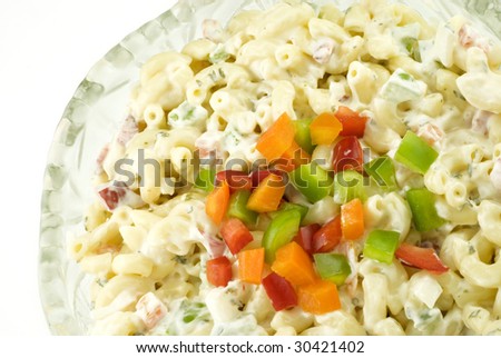 A bowl of macaroni salad with colorful chopped bell peppers in a crystal bowl, horizontal with copy space, top view