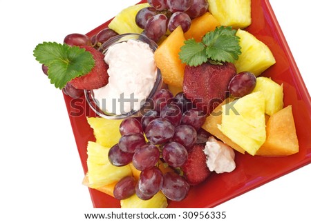 A plate of fresh cut fruit with fruit dip on a red plate, isolated on white background with copy space