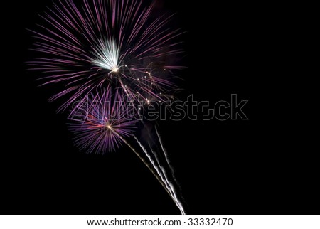 Beautiful purple fireworks bursts with black sky, horizontal with copy space