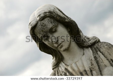 stock photo Cemetery statue of sad woman looking down closeup with blue