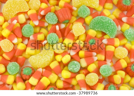 A background of colorful Halloween candy, candy corn, gumdrops and candy pumpkins, full frame, horizontal