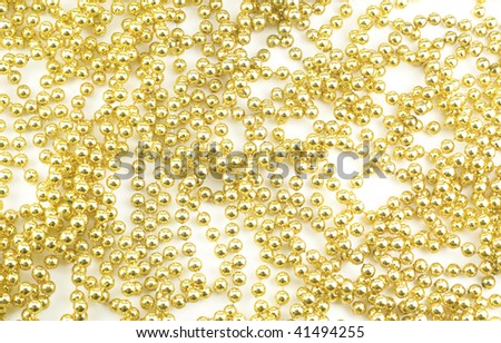 A full frame background with a string of shiny gold holiday beads, abstract
