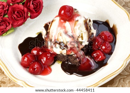 A delicious brownie sundae with vanilla ice cream, chocolate fudge syrup, and cherry topping, selective focus, perfect for Valentin\'s Day
