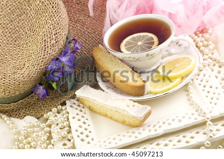 A ladies tea party with a cup of tea served on fine china, fresh lemon slices, and lemon biscotti on the side, perfect for Mother\'s Day