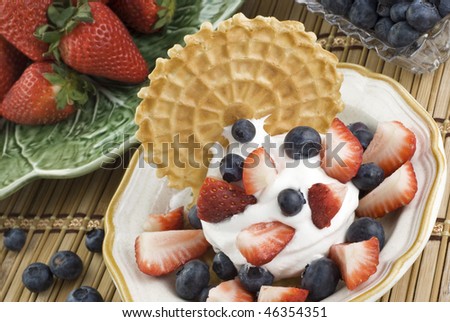 A strawberry blueberry dessert, made with whipped cream, fresh strawberries and blueberries and  an Italian cookie