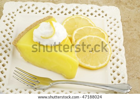 A slice of cool and refreshing lemon icebox pie topped with whipped cream and garnished with sliced lemons, horizontal with copy space