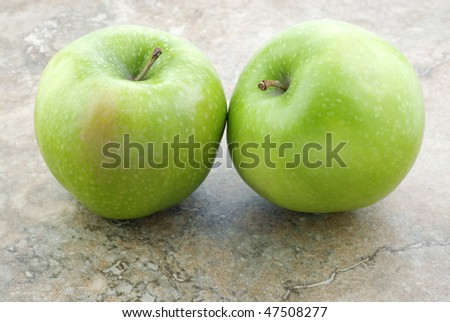 Two fresh green Granny Smith Apples on a horizontal vintage background, closeup with copy space