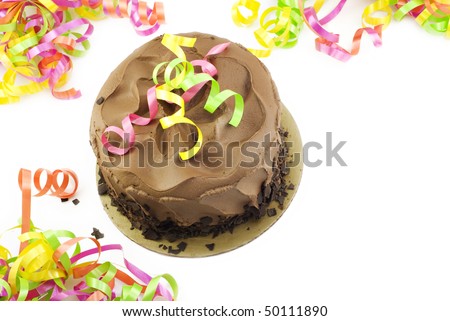 A chocolate fudge layer cake with colorful party ribbons on a white horizontal background with copy space, top view