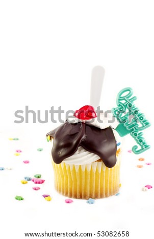 Happy Birthday Sundae Cupcake with fudge topping, cherry, plastic spoon and Happy Birthday decoration vertical on white background with sprinkles  copy space